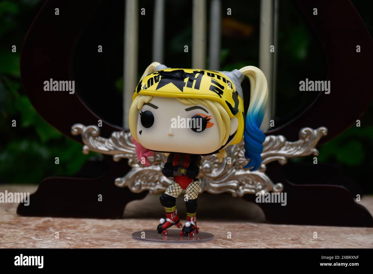 Funko Pop Actionfigur von Harley Quinn aus dem DC-Film Birds of Prey. Vinylspielzeug mit Helm und Rollschuhen, Vintage-Miniaturpavillon, Palast. Stockfoto