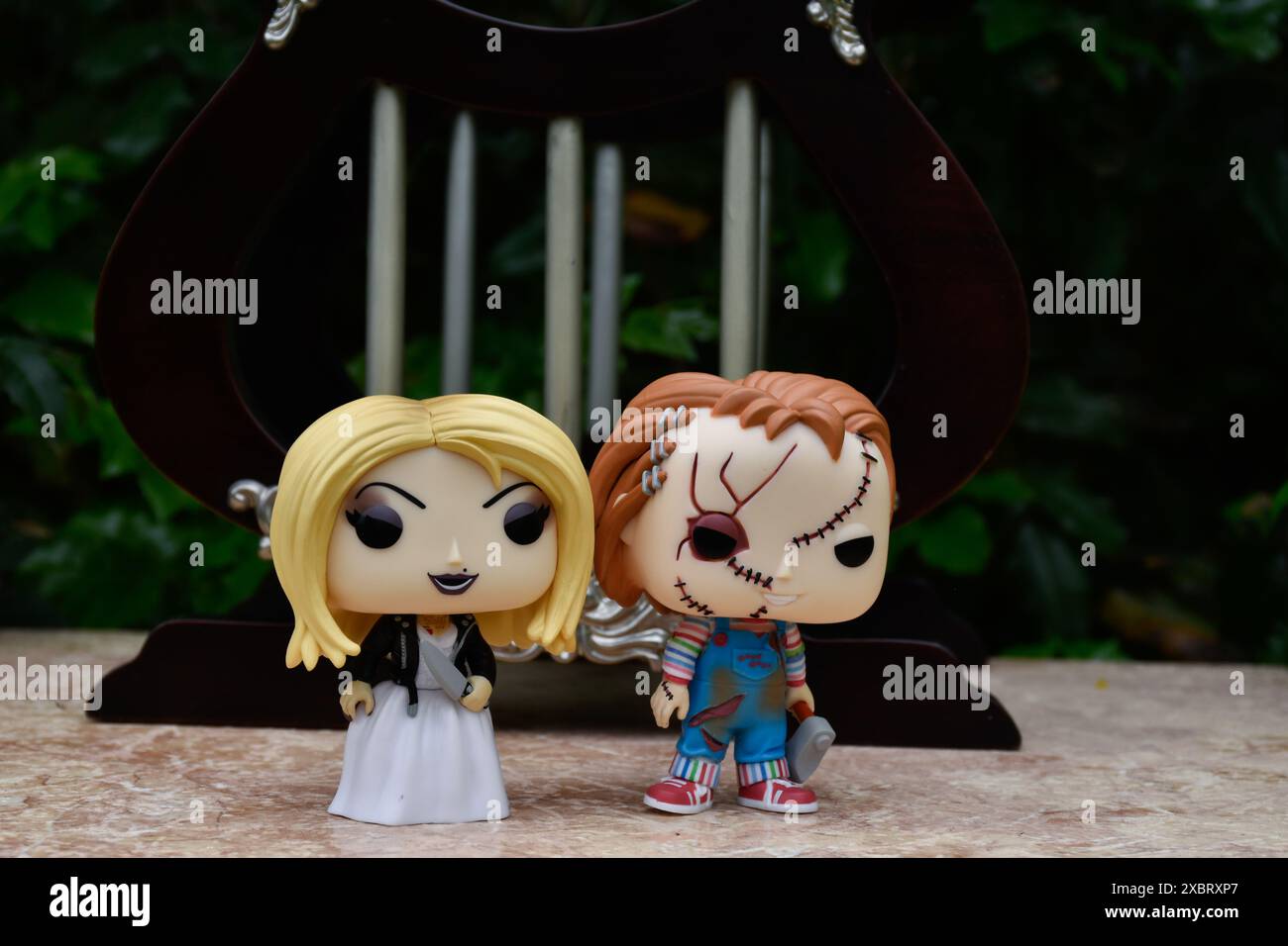 Funko Pop Actionfiguren von Tiffany und Chucky aus Horrorfilmen Child's Play. Killerpuppen, Miniaturpalast mit Säulen. Stockfoto