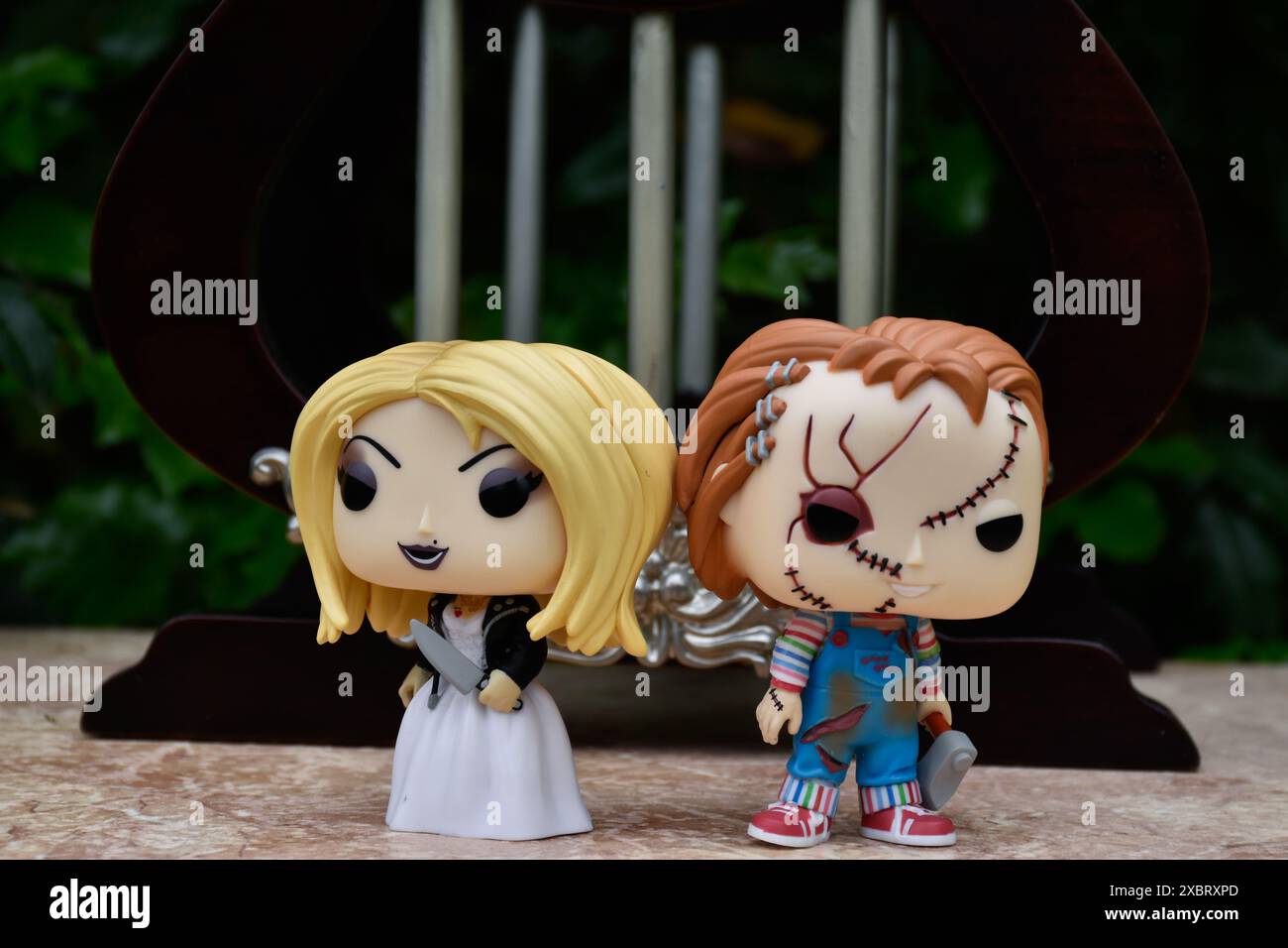 Funko Pop Actionfiguren von Tiffany und Chucky aus Horrorfilmen Child's Play. Killerpuppen, Miniaturpalast mit Säulen. Stockfoto