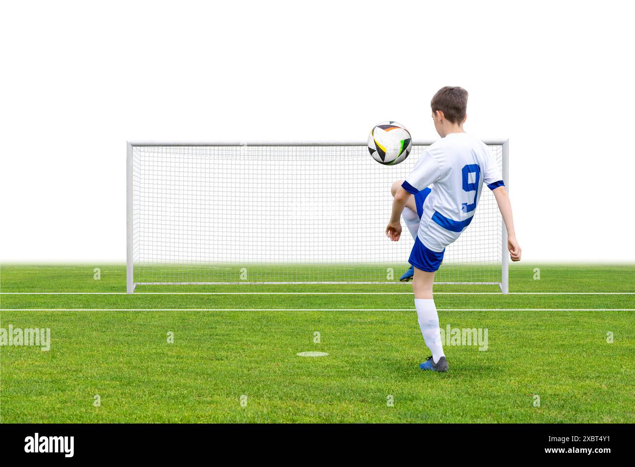 Fußballspieler jongliert mit einem Ball auf einem Feld mit einem Tor im Hintergrund. Perfekt für Sport-, Trainings-, Jugend- und Fitnessinhalte. Ideal für aktive LIFE Stockfoto