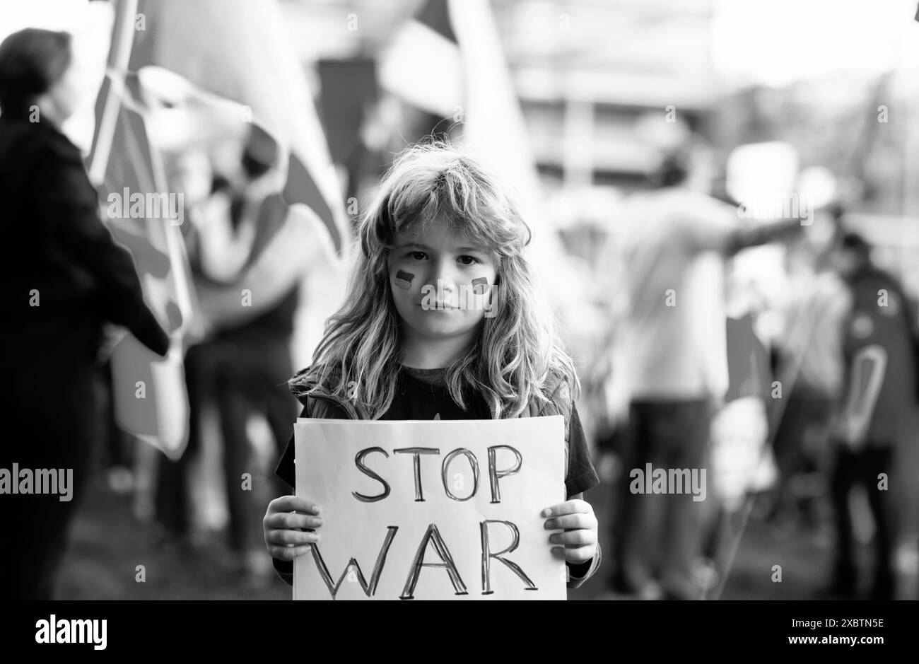 Porträt eines Jungen ruft den Krieg in der Ukraine zu stoppen und hält ein Plakat mit der Botschaft „Stoppt den Krieg“ im Freien. Russische Aggression. Kind trägt einen Stockfoto