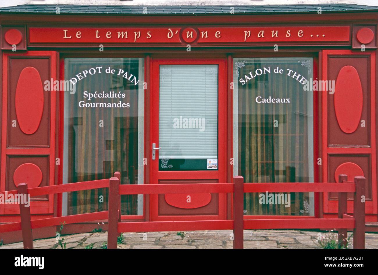 typisch französische Ladenfront in Rot: Salon de the in Pont-Croix, Bretagne * Vorderfenster und Tür eines französischen Teeladen Stockfoto