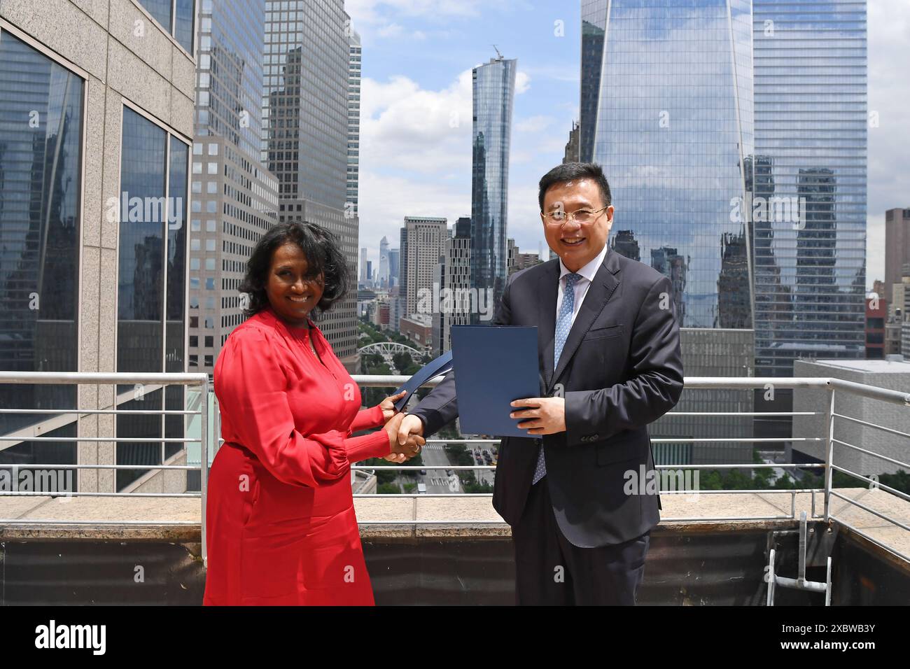 New York, USA. Juni 2024. Präsident der Nachrichtenagentur Xinhua Fu Hua und Daisy Veerasingham, Präsident und CEO der Associated Press (AP), tauschen am 12. Juni 2024 in New York, USA, unterzeichnete Kopie der Kooperationsvereinbarung aus. Fu Hua hat hier am Mittwoch Gespräche mit Daisy Veerasingham geführt. Quelle: Li Rui/Xinhua/Alamy Live News Stockfoto