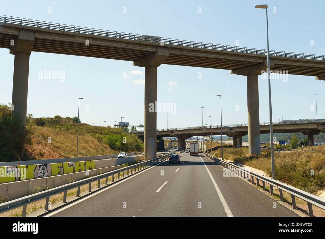 Barcelona, Spanien - 15. Mai 2023: Ein Auto fährt auf einer Autobahn unter einer Brücke in einer städtischen Umgebung. Stockfoto