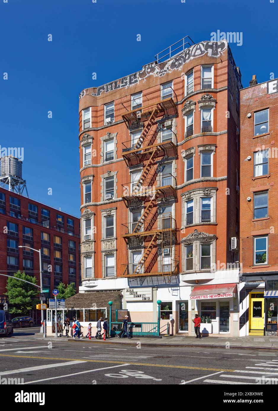 Kunstvoll verzierte Terrakotta-Spandrels und Fenster zieren dieses mittelhohe Apartment-Gebäude aus rotem Backstein in der Lower East Side von New York City. Stockfoto