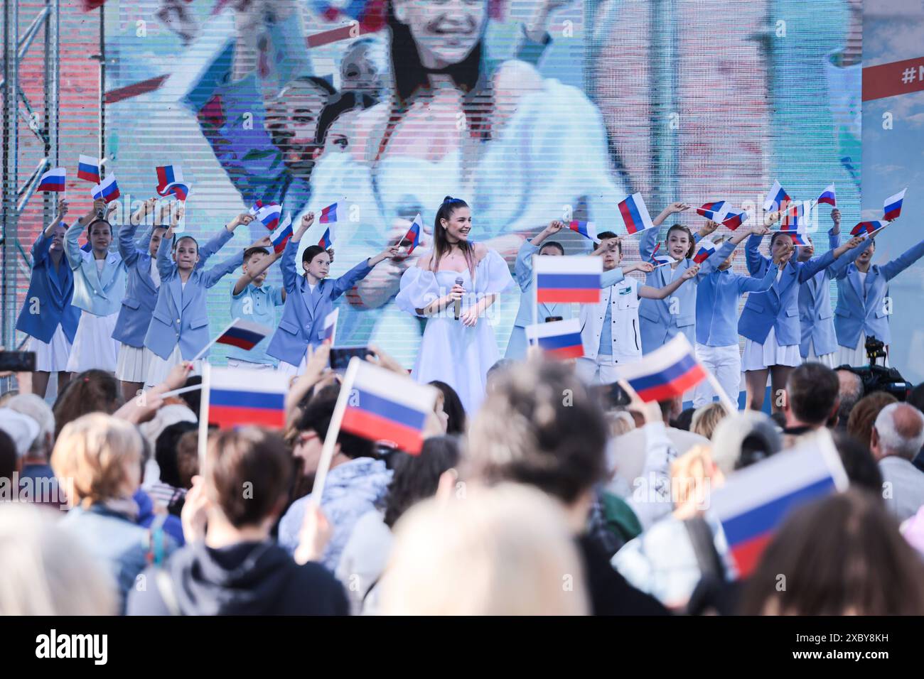 12. Juni 2024, St. Petersburg, Russland: Zuschauer und Teilnehmer des Festkonzerts zum Russland-Tag in der Peter-und-Paul-Festung in St. Petersburg schwenken Fahnen mit dem Dreikolore der Russischen Föderation. Viele zeremonielle Veranstaltungen fanden in St. Petersburg am Russland-Tag statt. Am Nachmittag fand im Alexandergarten der 'Ball der Nationalitäten' statt. Am Abend begann ein festliches Konzert auf dem Territorium der Peter-und-Paul-Festung unter Beteiligung des Gouverneurs von St. Petersburg, Alexander Beglov. Auf dem Gelände der Festung gab es verschiedene Themenspielplätze, wie z. B. Stockfoto