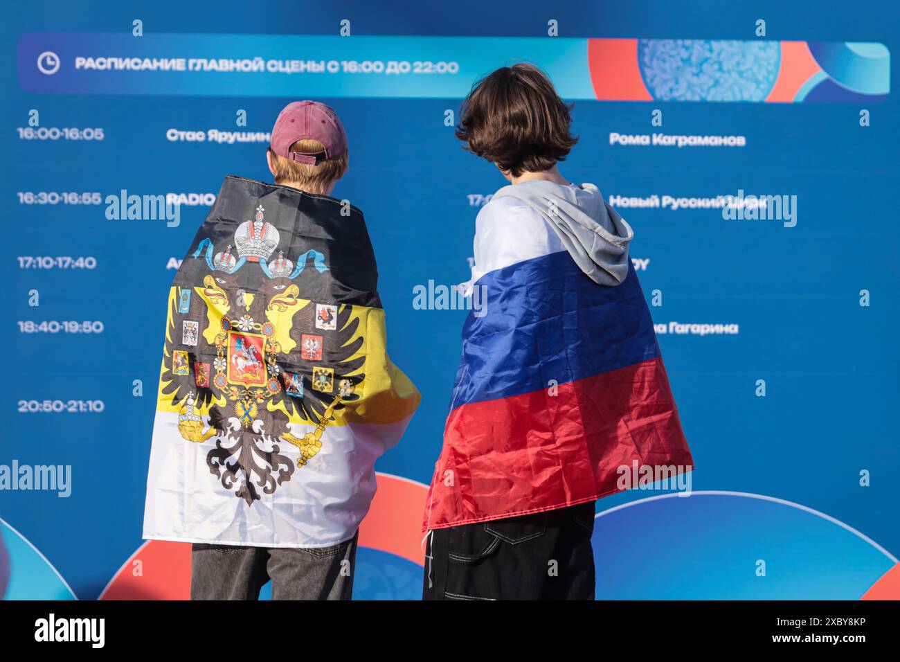St. Petersburg, Russland. Juni 2024. Menschen stehen an einem Informationsstand, der in kaiserliche und russische Fahnen gewickelt ist, während der Feierlichkeiten zum russischen Tag in St. Petersburg. Viele zeremonielle Veranstaltungen fanden in St. Petersburg am Russland-Tag statt. Am Nachmittag fand im Alexandergarten der 'Ball der Nationalitäten' statt. Am Abend begann ein festliches Konzert auf dem Territorium der Peter-und-Paul-Festung unter Beteiligung des Gouverneurs von St. Petersburg, Alexander Beglov. Auf dem Gelände der Festung gab es verschiedene Themenspielplätze sowie Meisterkurse zum Kunsthandwerk. Außerdem Stockfoto