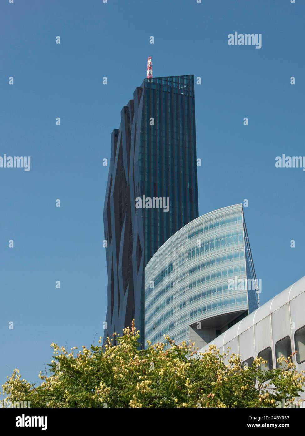 Modernes Gebäude mit Glasfassade und markantem Design unter klarem blauem Himmel, Bäume davor, Wien, Österreich Stockfoto