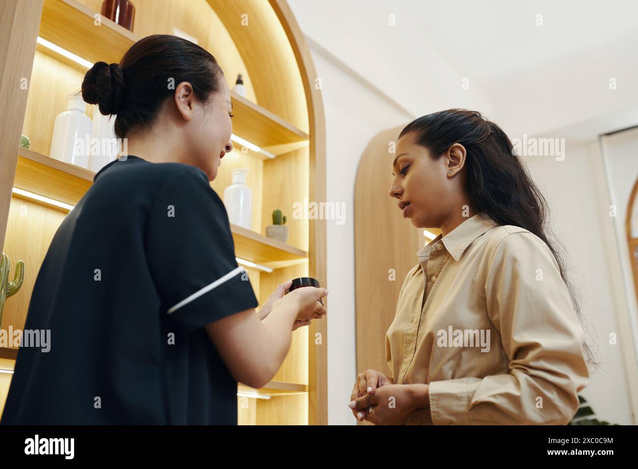 Der Manager des Spa-Salons empfahl dem Gast Gesichtscreme Stockfoto