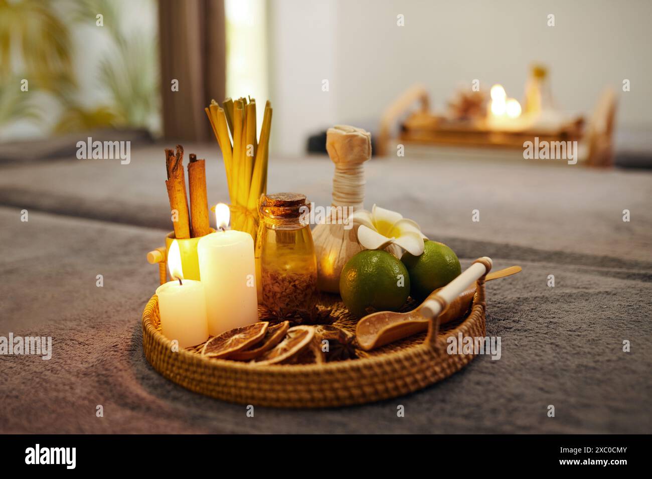 Korbtablett mit brennenden Kerzen, Aromaölen und Früchten für Spa-Behandlungen Stockfoto