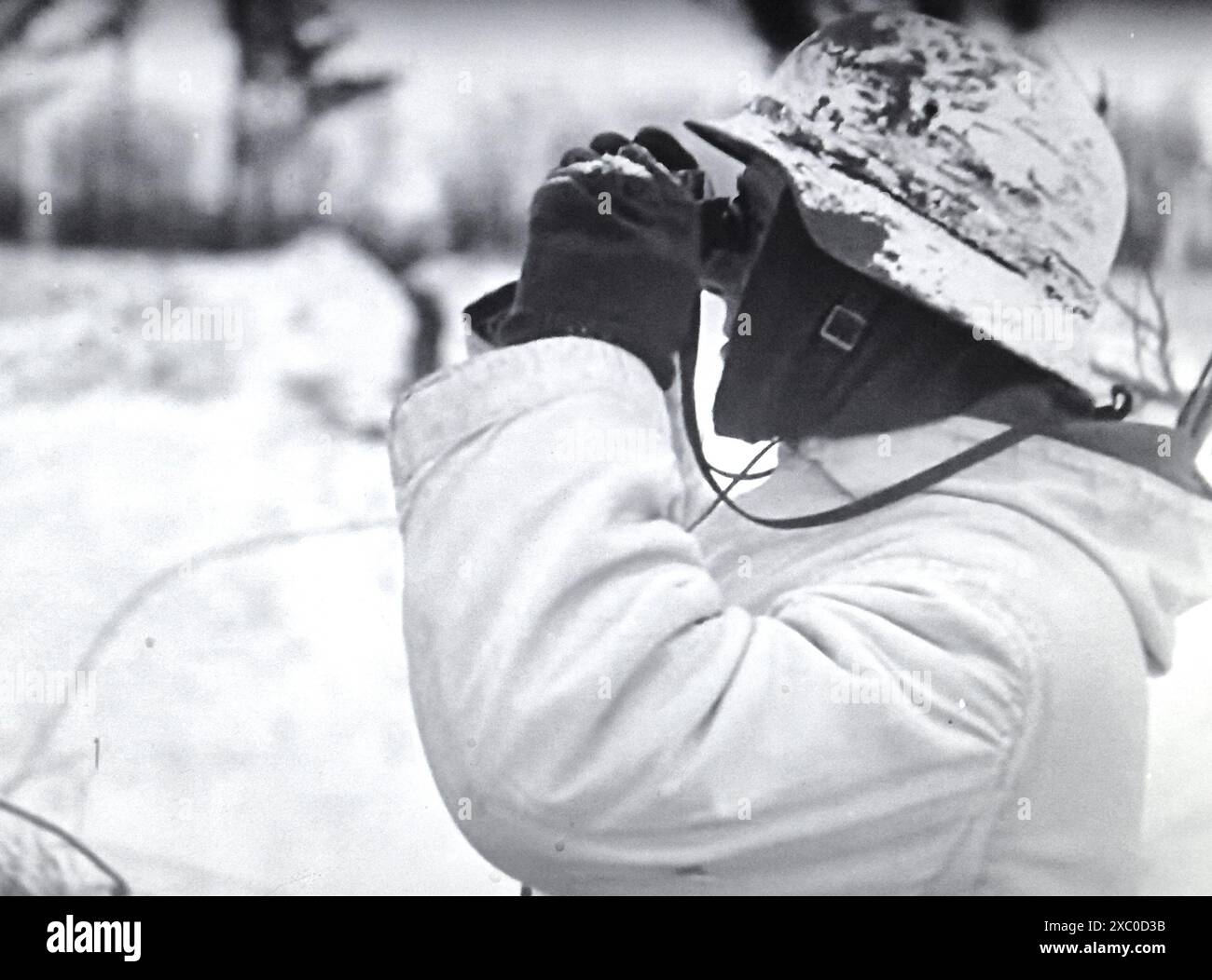 Screenshot des Zweiten Weltkriegs in Schwarzweiß. Ein deutscher Soldat im Winter-Schnee-Camo mit Feldbrille hält im Februar 1943 an der Russischen Front Wache für feindliche Truppen Stockfoto