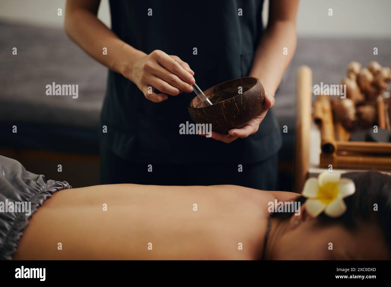 Masseurin mit Peeling auf dem Rücken der jungen Frau, um tote Haut zu entfernen Stockfoto