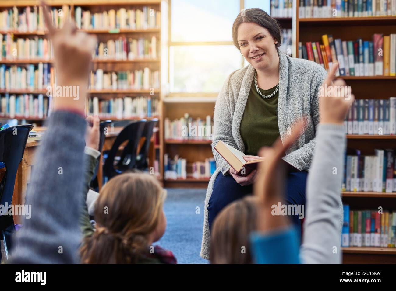 Bibliothek, Kinder und Lehrer lesen Buch, Fragen und Bildung mit Wissen, Geschichten und Kindergarten. Erzieher, Frauen- und Kinderhände Stockfoto