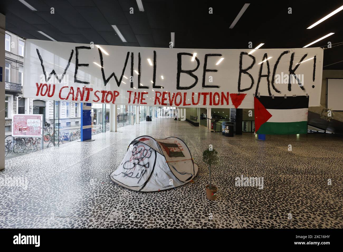 Ein Zelt und ein Banner mit der Aufschrift „Wir werden zurück sein“ im leeren Gebäude, nach der fortgesetzten Besetzung durch Studenten, um Solidarität mit dem palästinensischen Volk zu zeigen und am Freitag, den 14. Juni 2024, im Rektorat von UGent einen sofortigen Waffenstillstand im israelisch-Hamas-Konflikt zu fordern. Gestern hat das Berufungsgericht Gent den Antrag auf Räumung pro-palästinensischer Dämonen aus dem UFO-Gebäude in UGent für gerechtfertigt erklärt und den Besatzern 12 Stunden nach Verkündung des Urteils gegeben, die Räumlichkeiten der Universität Gent zu verlassen. BELGA FOTO JONAS DHOLLANDER Stockfoto