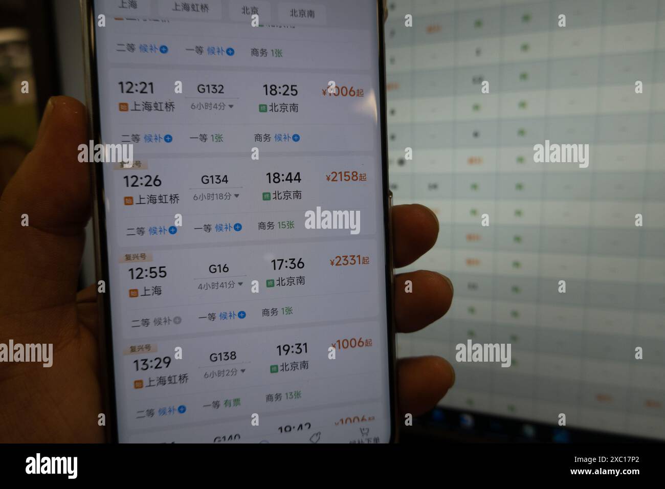 HANGZHOU, CHINA - 14. JUNI 2024 - Ein junger Mann sucht über die APP und Website für die Bahnfahrkarten 12306 in Shanghai, China, 14. Juni 20 nach Tickets Stockfoto