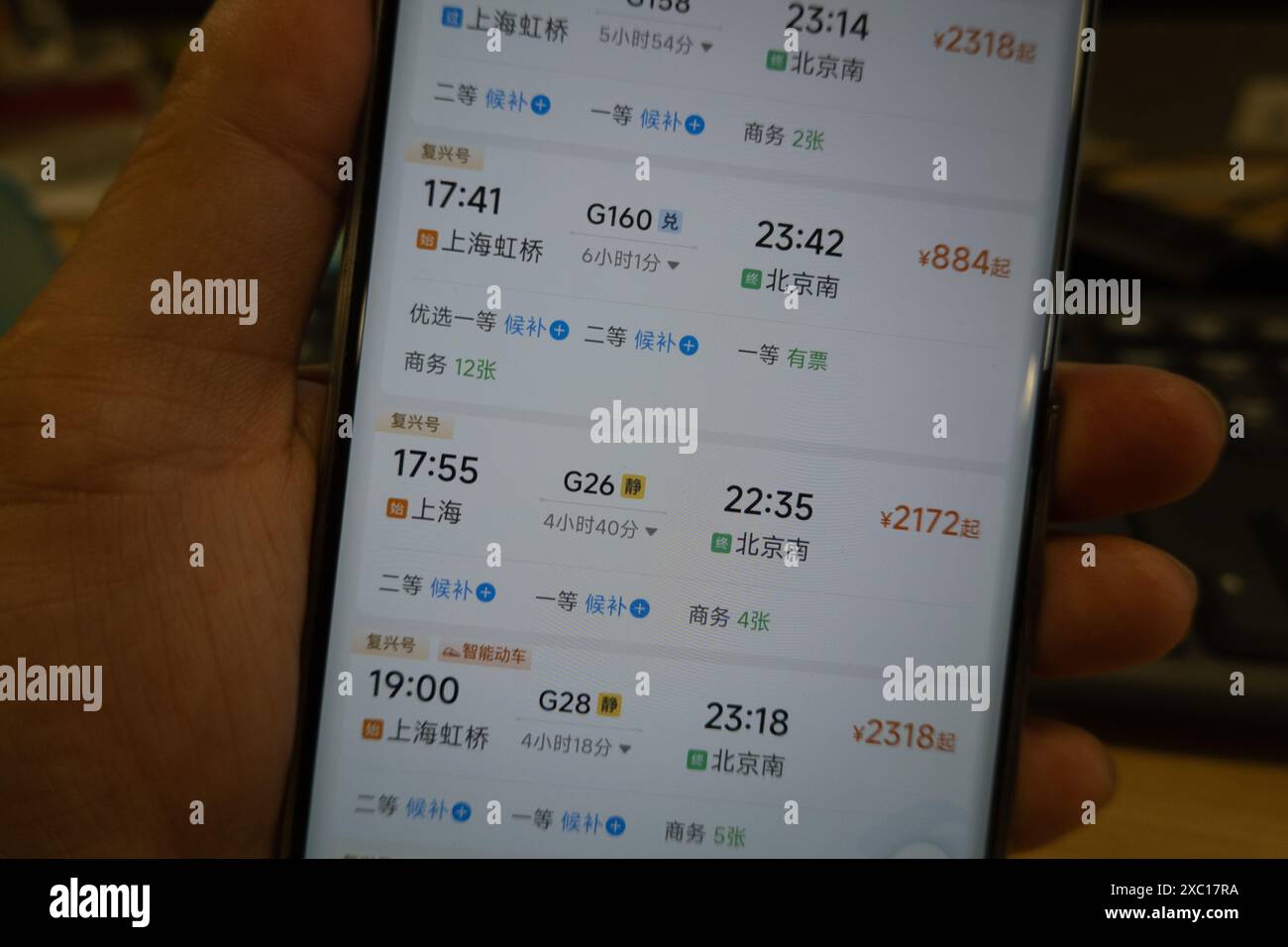 HANGZHOU, CHINA - 14. JUNI 2024 - Ein junger Mann sucht über die APP und Website für die Bahnfahrkarten 12306 in Shanghai, China, 14. Juni 20 nach Tickets Stockfoto