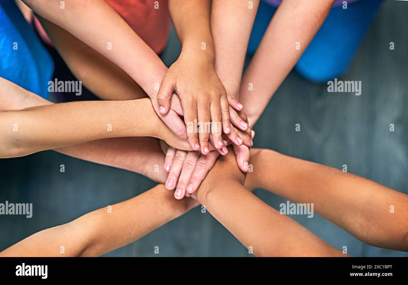 Kinder, Hände zusammen und Solidarität für Unterstützung, Vertrauen und Errungenschaften im Bildungsbereich. Schüler, Kinder und Zusammenarbeit für Teamarbeit, Erfolg und Stockfoto