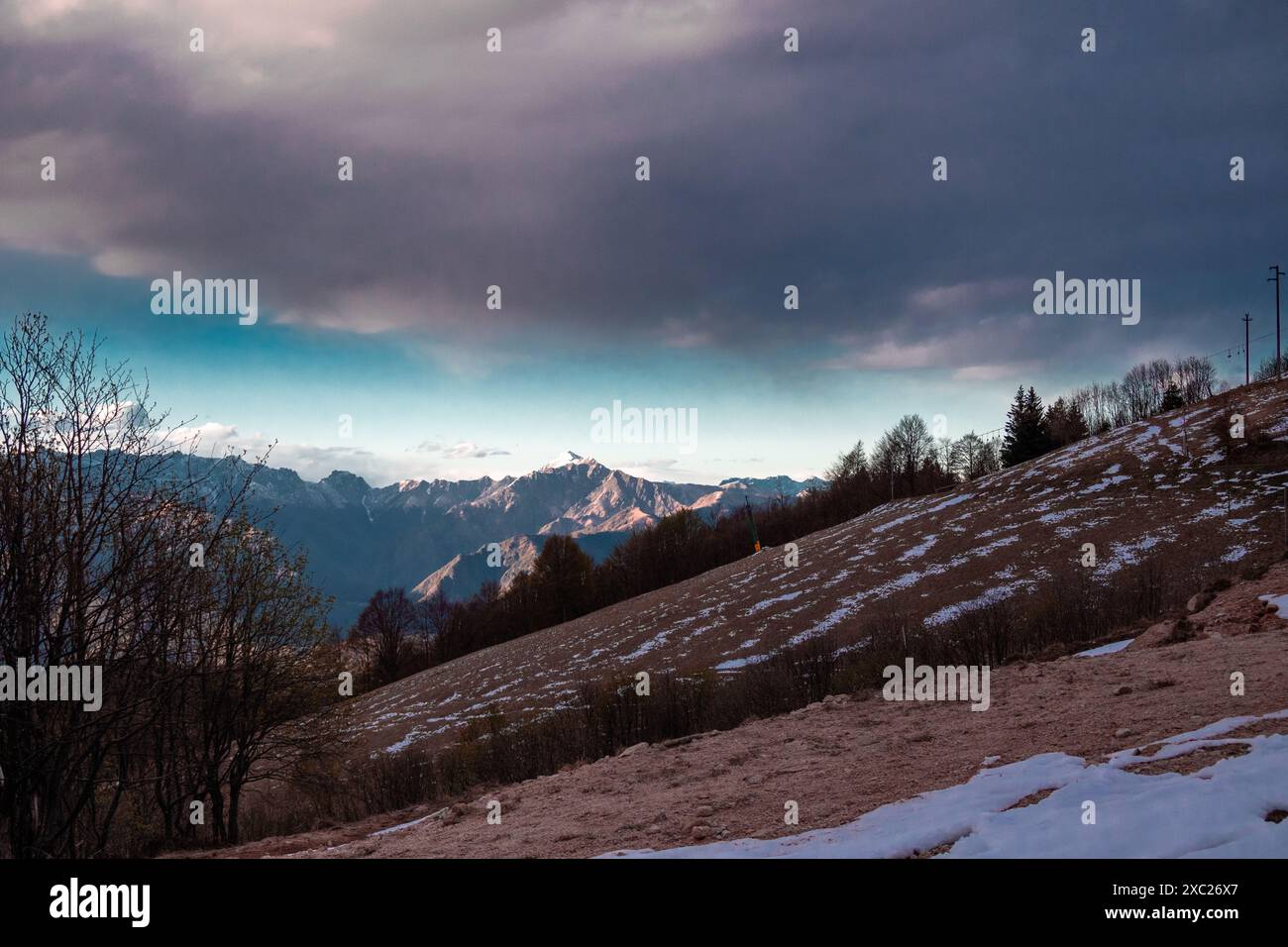 Malerischer Blick auf die Berge vor dem Himmel bei Sonnenuntergang. . Eindrucksvolle Winterlandschaft mit Bergen, die von den Sonnenstrahlen beleuchtet werden. Stockfoto