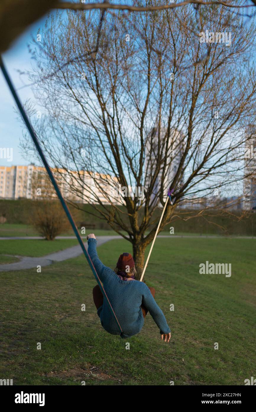 Junger Mann, der auf einer Slackline sitzt. Stockfoto