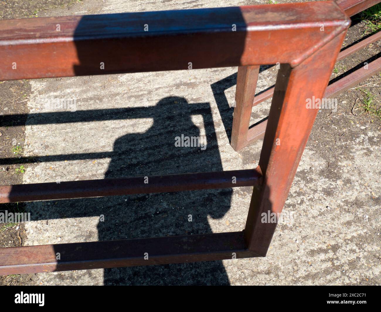 Mein Schatten und ein offenes Fußwegentor begrüßen mich auf einem meiner Lieblingswanderungen von meinem Heimatdorf Radley in Oxfordshire hinunter zur Themse. Stockfoto