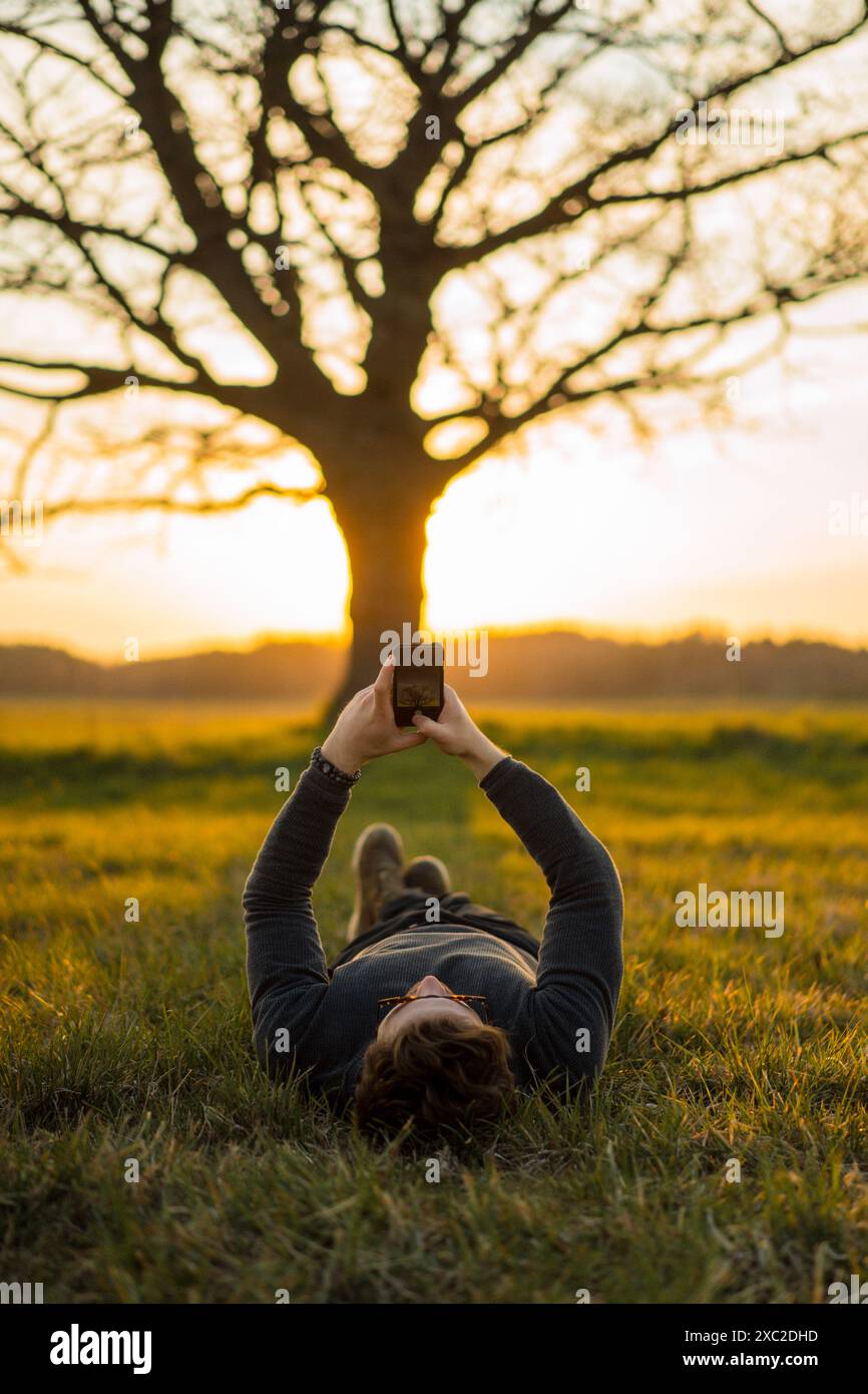 Der Mann macht ein Foto von der Natur, Sonnenuntergang am Telefon. Reisende. Stockfoto