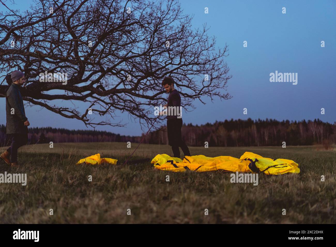 Ein Mann baut ein Zelt auf einem Campingausflug im Wald. Stockfoto