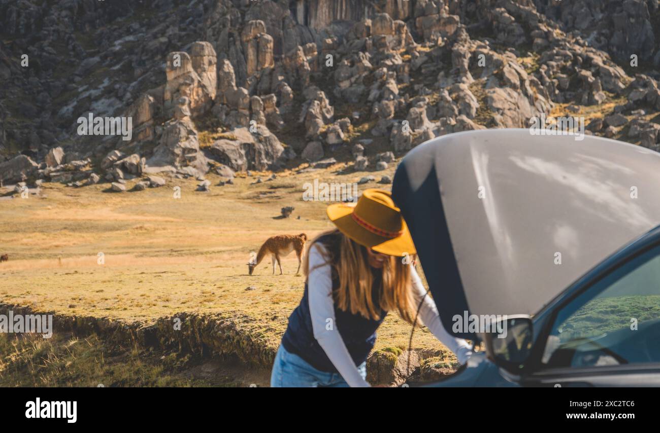 Eine Frau steht neben einem Auto mit gelbem Hut Stockfoto