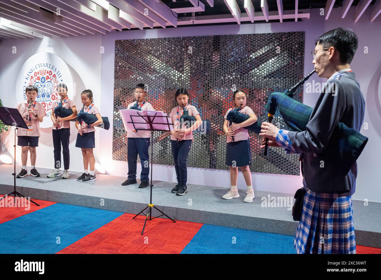 Chris Lee (rechts) leitet eine Gruppe von Schülern seiner English School Foundation, die bei der Eröffnung des St. Andrew's Society Piping and Drumming Fund für Gäste auftreten. Hongkong beherbergt Hunderte von Pipern und Drummern und verfügt über eine umfangreiche Geschichte schottischer Musik, die mit den Streitkräften verbunden ist, sowie über Gedenkveranstaltungen. Der Fonds soll die wachsende Gemeinschaft schottischer Musikbegeisterter in HK unterstützen, darunter ein lokales Team unter der Leitung von Chris Lee, das diesen Sommer nach Glasgow reisen wird, um HK zum ersten Mal bei den Pipe Band World Championships zu vertreten. Stockfoto