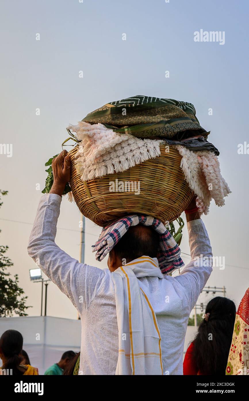 Menschen, die heilige Opfergabe am Kopf tragen, anlässlich des Chhath-Festivals in indien Stockfoto