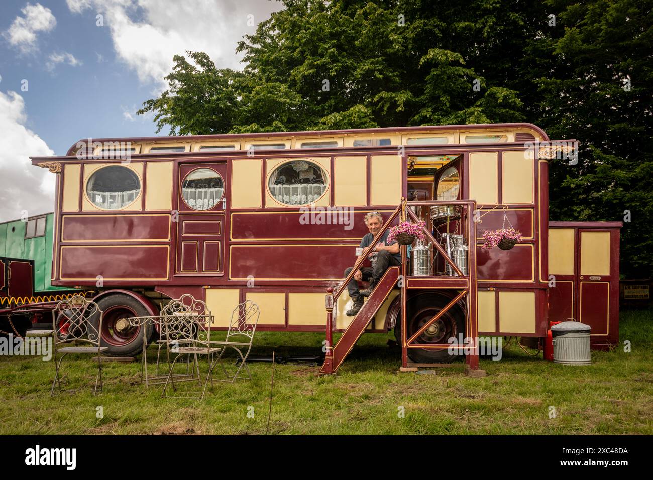 jon Cheese sitzt auf den Stufen seines restaurierten Showman Carriage aus den 1930er Jahren, der einst mit Entertainern und Zirkuskünstlern durch Großbritannien reiste, um sich auf das Wochenende High Weald Steam Working Weekend, Pippingford Park Nutley, East Sussex, UK, vorzubereiten Stockfoto