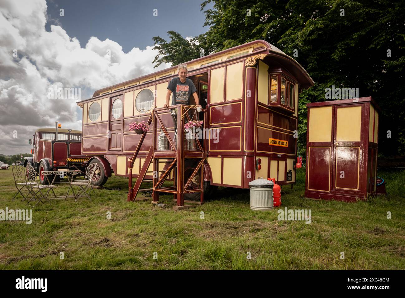 Jon Cheese sitzt auf den Stufen seines restaurierten Showman Carriage aus den 1930er Jahren, der einst mit Entertainern und Zirkuskünstlern durch Großbritannien reiste, um sich auf das Wochenende High Weald Steam Working Weekend, Pippingford Park Nutley, East Sussex, UK, vorzubereiten Stockfoto