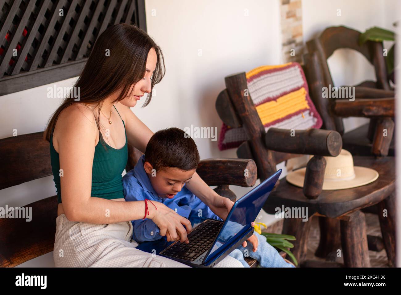 Lebensstil: Junge Frauenstudien am Laptop mit Bruder mit Down-Syndrom Stockfoto