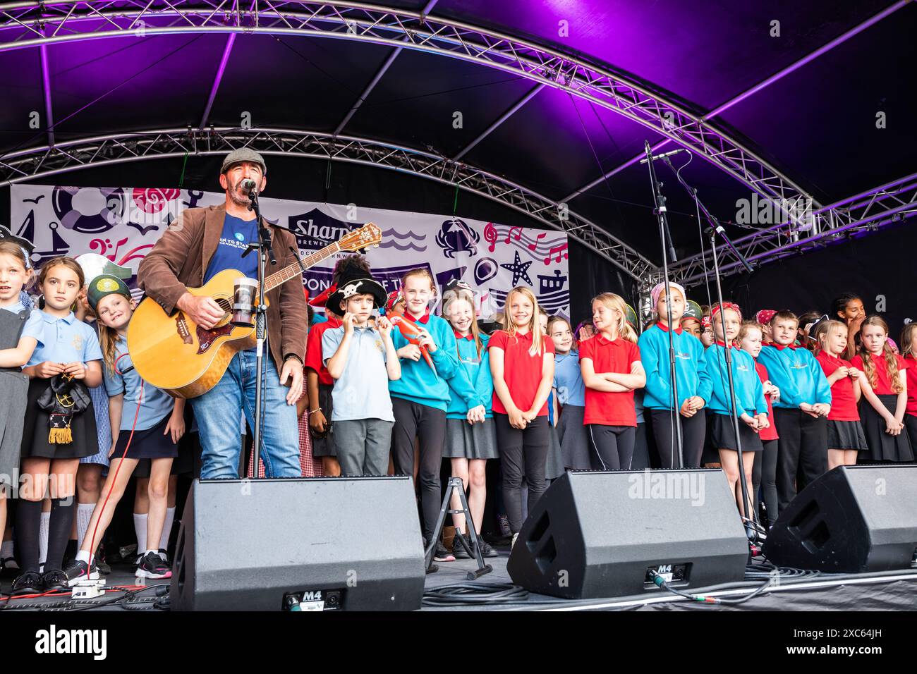 Falmouth, Cornwall, 14. Juni 2024, das Falmouth International Sea Shanty Festival ist das ganze Wochenende über im Gange. Riesige Menschenmassen waren anwesend, um all die SEA Shanty's zu beobachten und zu hören Will Keating besuchte und spielte auf der Bühne zusammen mit den Kindern der Falmouth Primary School und lehrte ihnen, wie man auf Cornish bis zehn zählt. Quelle: Keith Larby/Alamy Live News Stockfoto