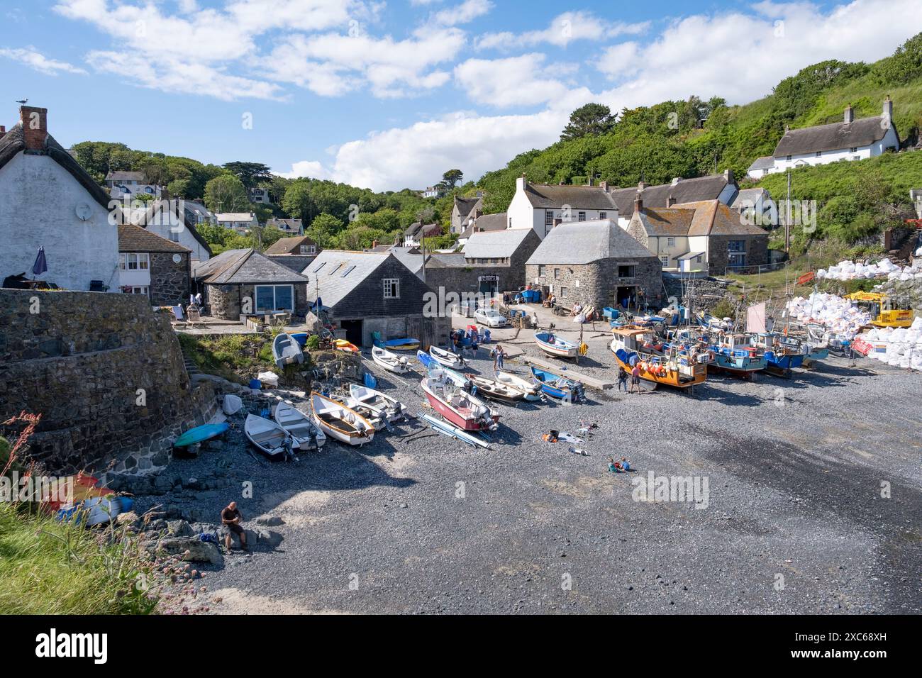 Der Fischerhafen im Dorf Cadgwith, Cornwall, England, mit Handwerkskunst am Kieselstrand. Stockfoto