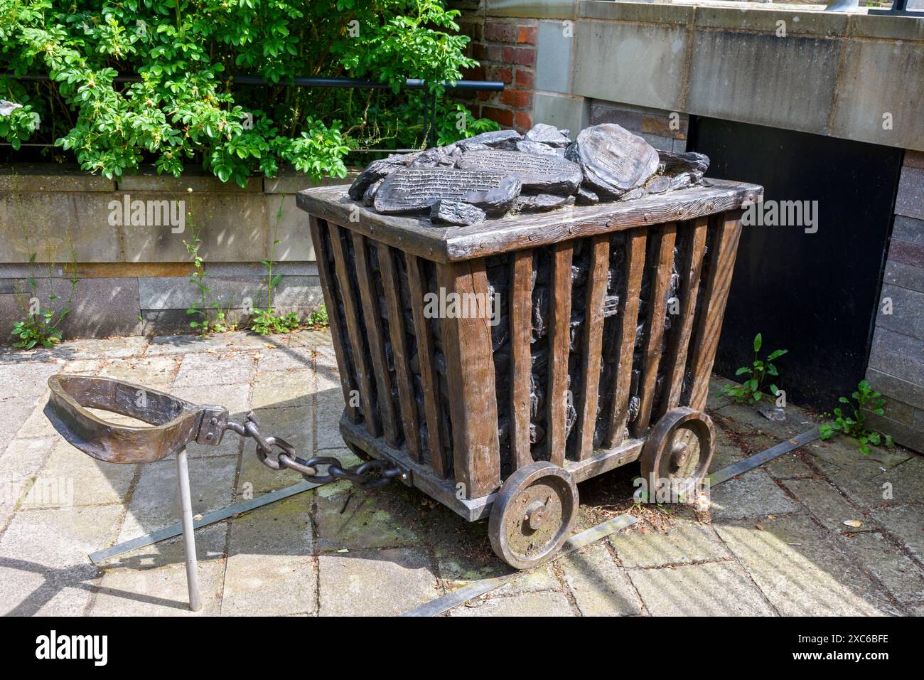 Skulptur von Bronzecast. Abbildung eines Kohlewagens mit Gurtzeug, der normalerweise von Frauen gezogen wird, die als „Schubladen“ bezeichnet werden. In Worsley Delph, Salford, England, Großbritannien. Stockfoto