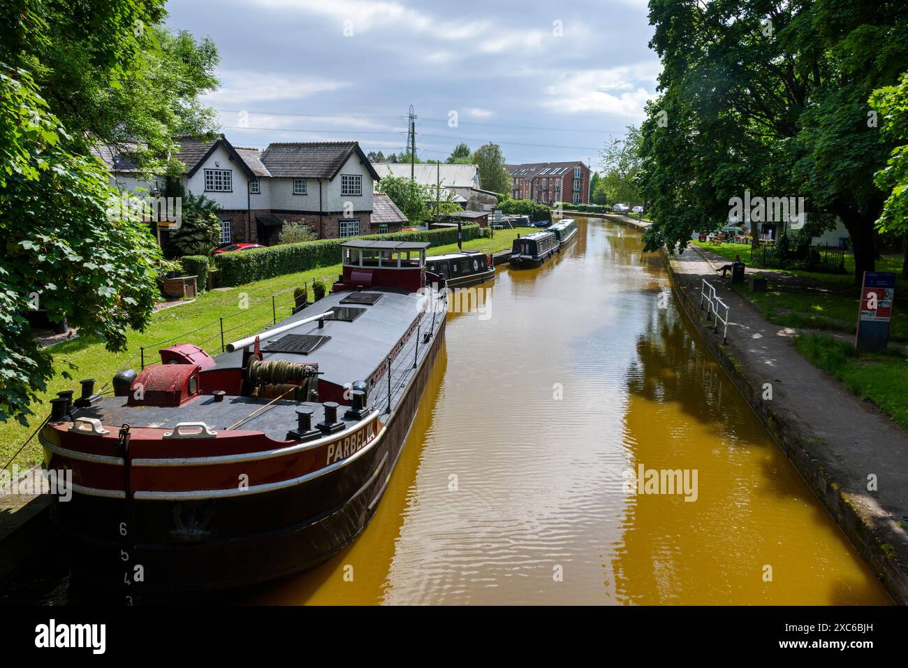Ein kommerzielles Boot und mehrere Kanalschmalboote auf dem Bridgewater Canal in Worsley, Salford, Greater Manchester, England, Großbritannien Stockfoto