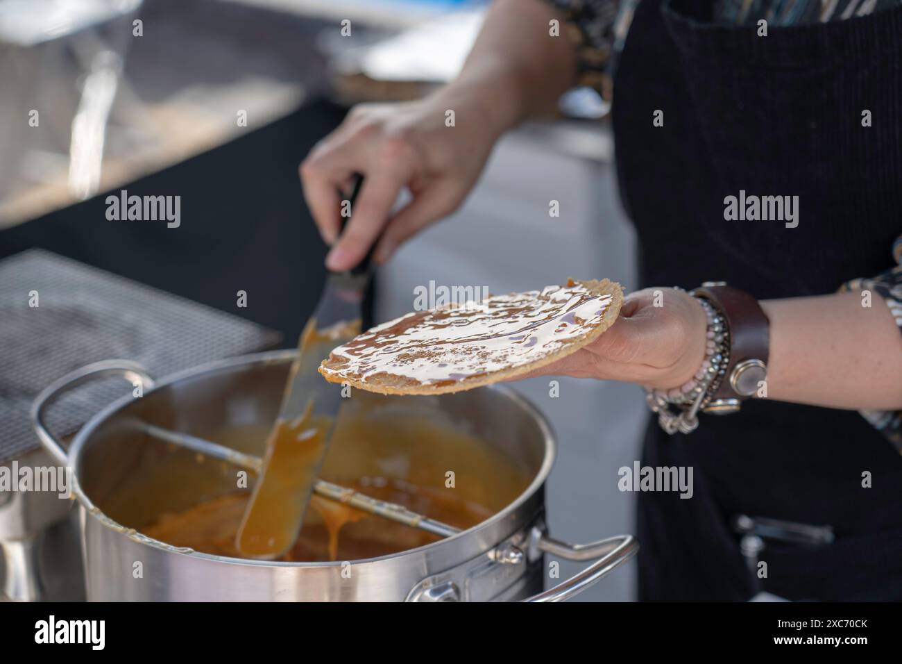 Person auf lokalen Märkten in den Niederlanden, die holländische Waffeln mit Stroopwafel zubereitet. Stockfoto