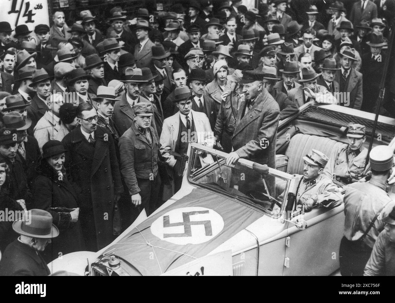 Ein Mann, der in einem Auto in einer überfüllten Berliner Straße steht. Dieses Foto stammt vom 1. April 1933, während der landesweiten antisemitischen Boykott- und Propagandakampagne gegen jüdische Unternehmen. Der Mann ermutigt die Massen, sich am Boykott zu beteiligen. Stockfoto