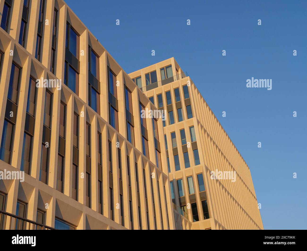 Modernes Bürogebäude mit sandfarbener, geometrischer Fassade vor blauem Himmel, Bremen, Deutschland Stockfoto