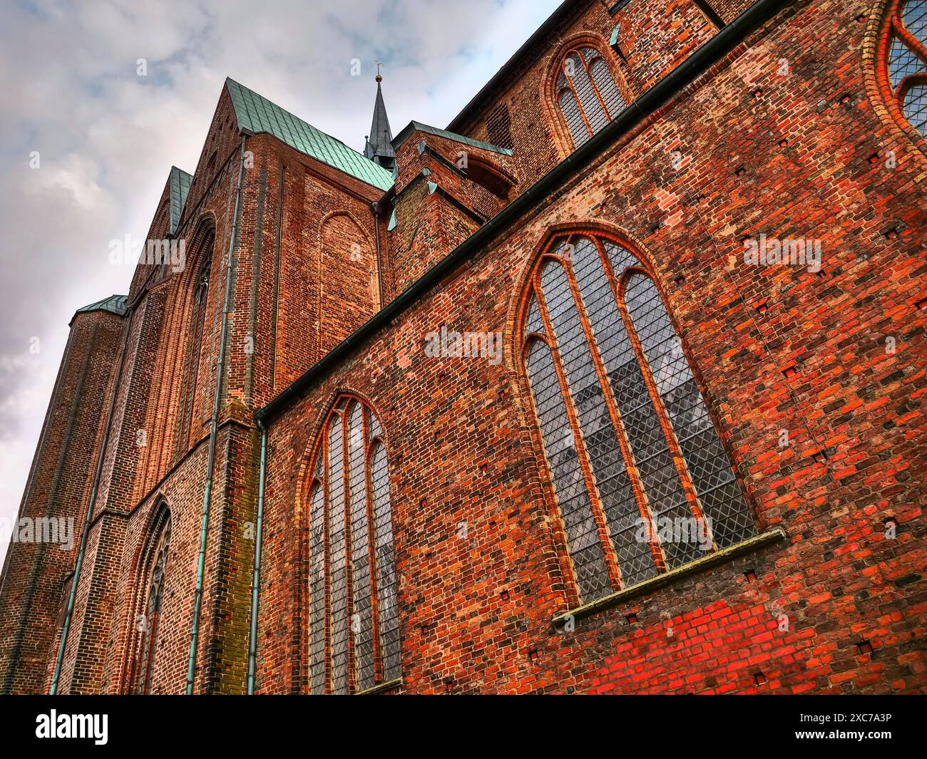 Gotische Kathedrale aus roten Ziegeln mit hohen Fenstern unter bewölktem Himmel, Gothmund, travemünde, lübeck, deutschland Stockfoto