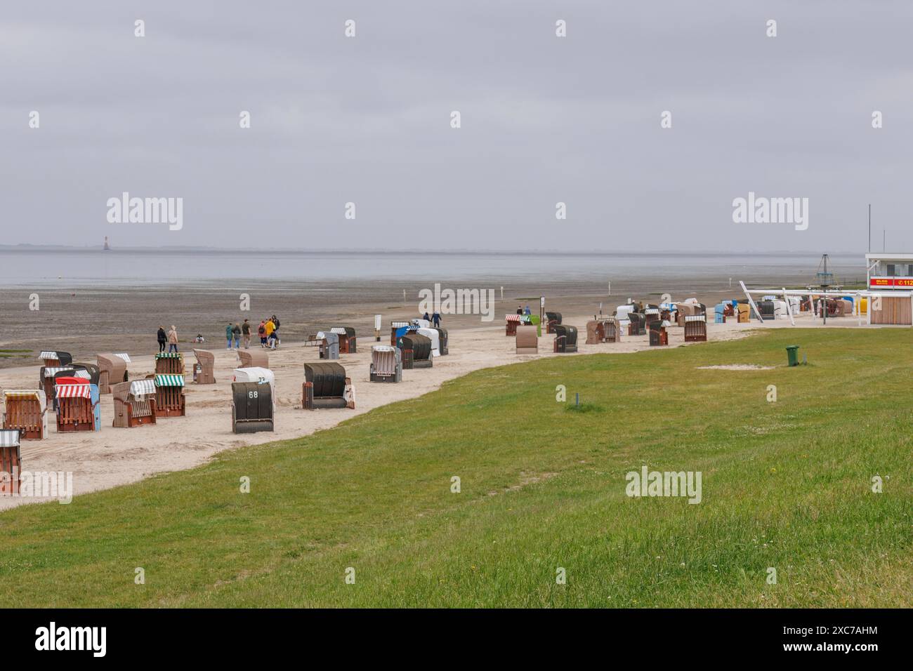 Eine Sammlung von Liegestühlen entlang einer Küste an einem grauen Tag, Dangast, varel, deutschland Stockfoto