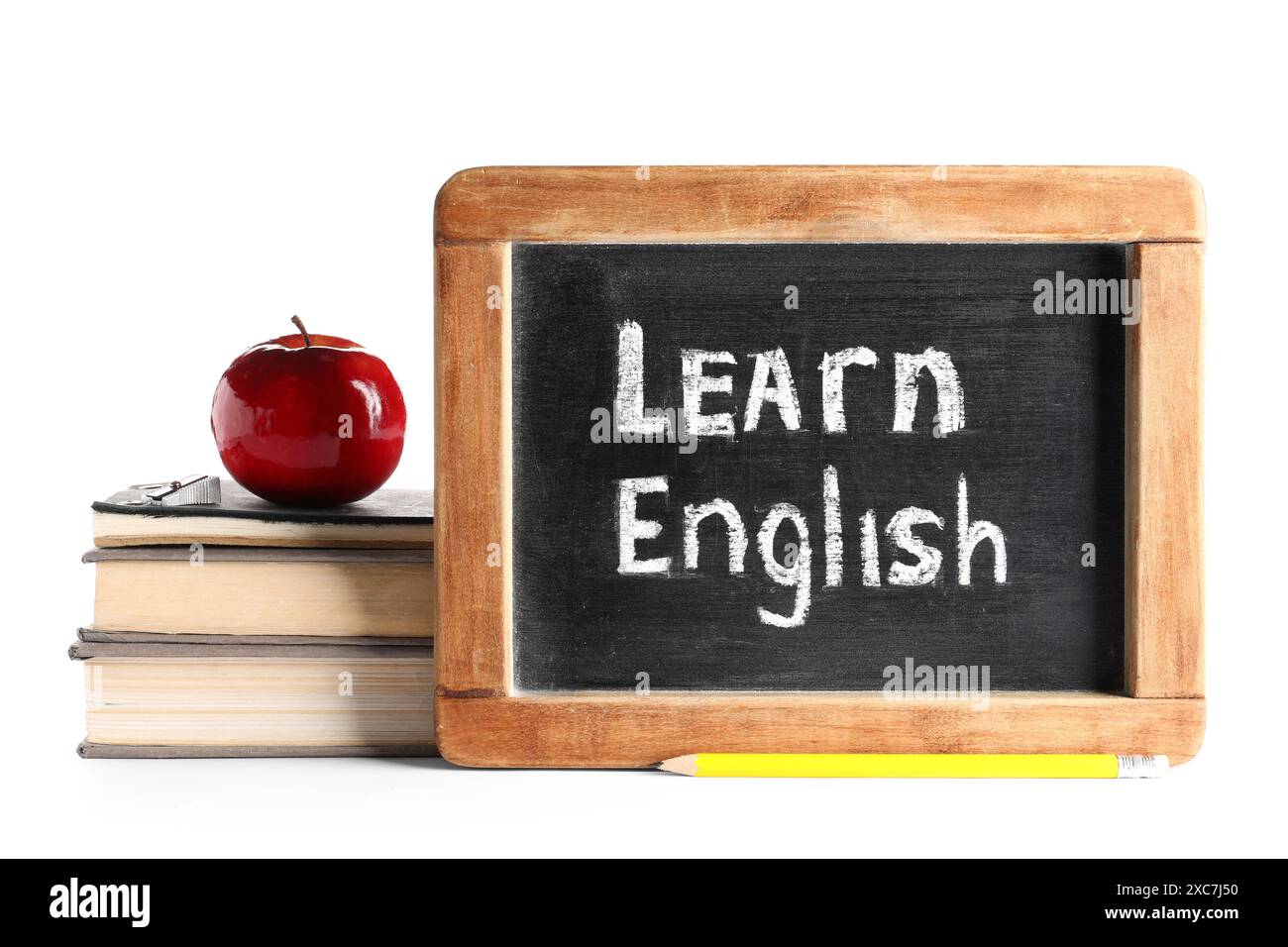 Bücher, frischer Apfel und Tafel mit Text LERNEN ENGLISCH isoliert auf weißem Hintergrund Stockfoto