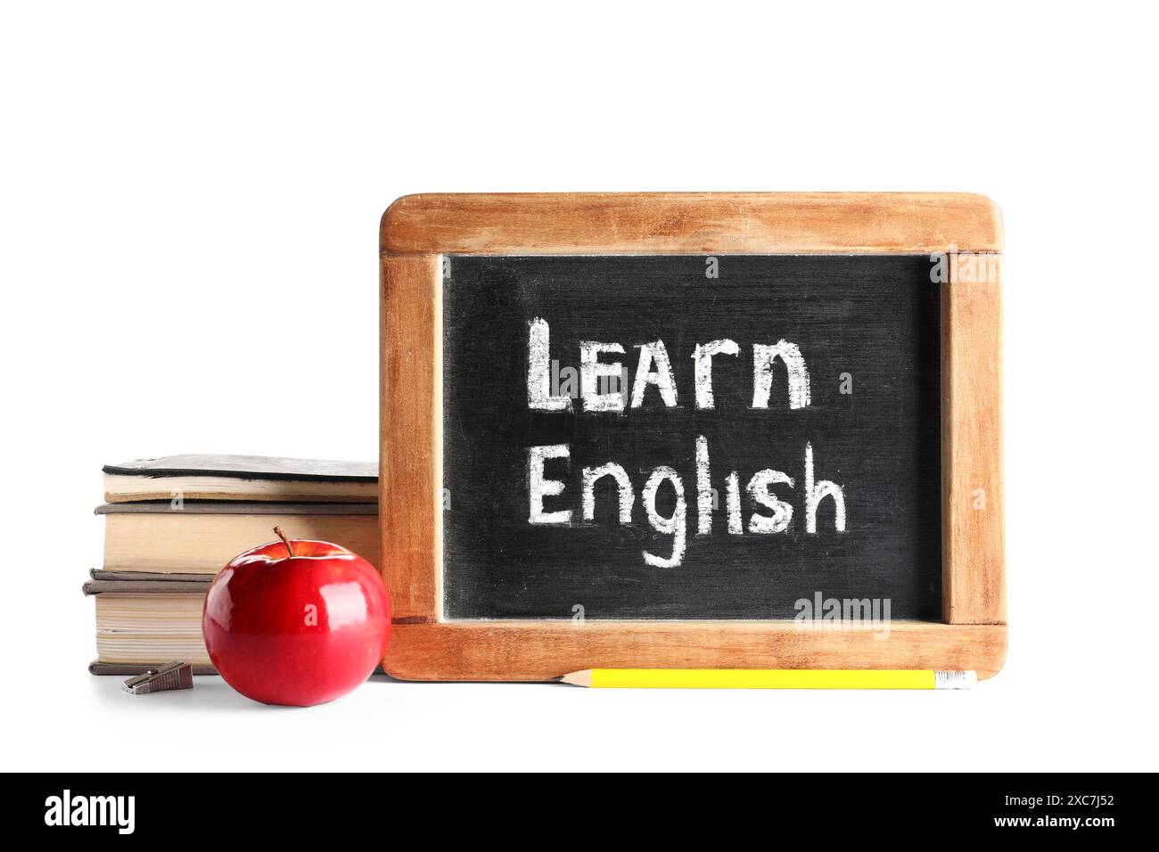Bücher, frischer Apfel und Tafel mit Text LERNEN ENGLISCH isoliert auf weißem Hintergrund Stockfoto