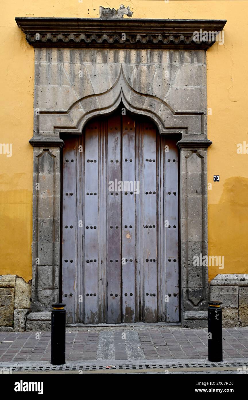 GUADALAJARA, JALISCO, MEXIKO: Eine alte Holztür in einer Seitenstraße in Zona Centro, Guadalajara, Jalisco, Mexiko. Stockfoto