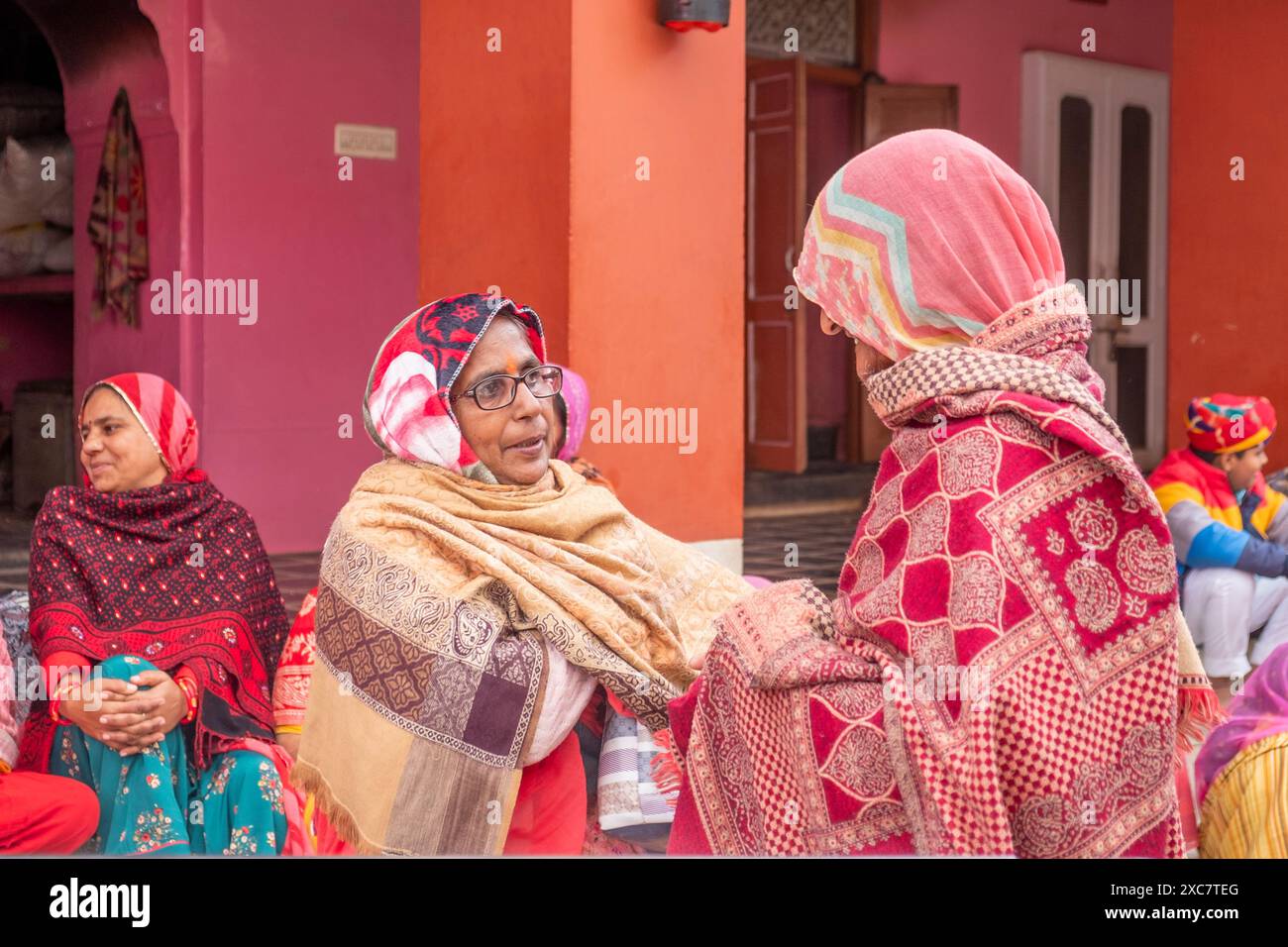 Deshnoke, Indien - 12. Februar 2024: Attraktive indische Frauen in traditioneller Kleidung sitzen auf den Stufen des Deshnoke-Tempels und haben Spaß beim Vortrag Stockfoto