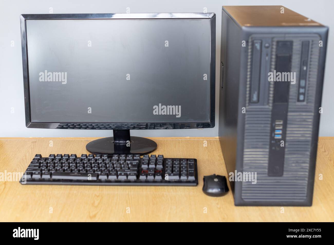 Desktop-Computer-Set mit Monitor, Tastatur und Maus auf Holzschreibtisch Stockfoto
