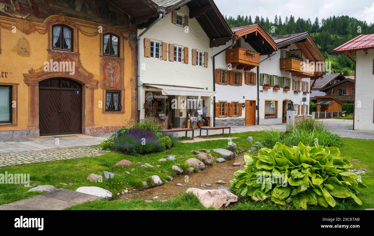 Die Marktgemeinde Mittenwald mit historischen Gebäuden Mittenwald liegt im Landkreis Garmisch-Partenkirchen, ist Deutschlands höchstgelegener Luftkurort und berühmt wegen der traditionellen Kunst des Geigenbaus. In der historischen Altstadt sind viele Häuser auf der Fassade mit kunstvoller Lüftlmalerei geschmückt. Direkt neben der historischen Altstadt liegt der Ortsteil Gries mit seinen historischen Gebäuden und den mit Blumen- und Pflanzenschmuck aufwendig gestaltete Freiflächen. Mittenwald Bayern Deutschland *** die Marktstadt Mittenwald mit historischen Gebäuden Mittenwald befindet sich in Stockfoto