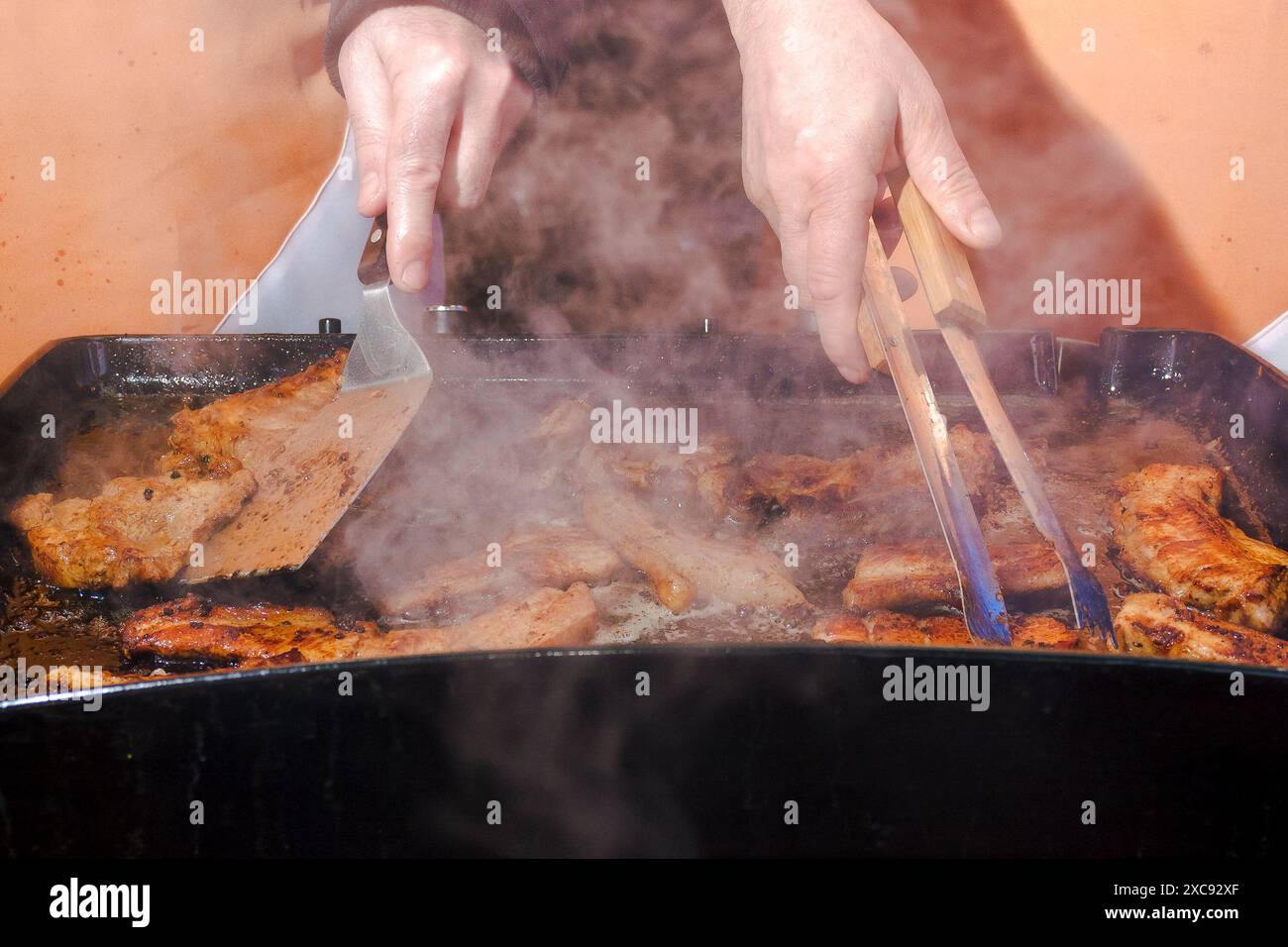 Nahaufnahme des Frittierprozesses. Hintergrund zum Kochen von Speisen im Freien. Blick durch Rauch Stockfoto