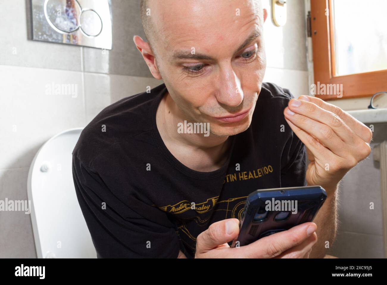 Weißer Mann, der tagsüber im Bad telefoniert Stockfoto