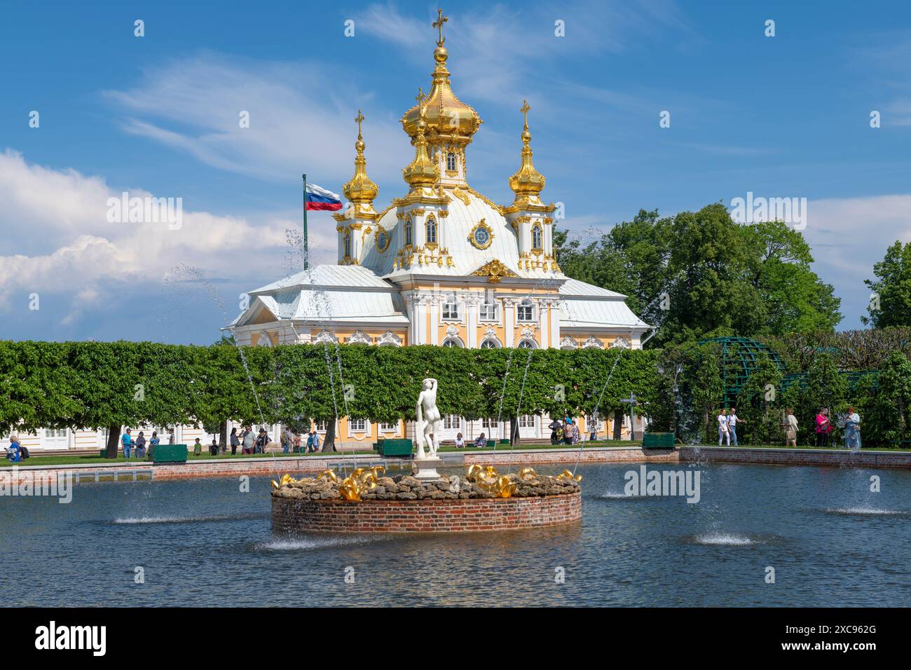 PETRODVORETS, RUSSLAND - 04. JUNI 2024: Brunnen und Kirche von Peter und Paulus der Peterhof Schlossanlage an einem sonnigen Tag Stockfoto